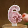 Pink glitter number six candle with a pink bow decoration