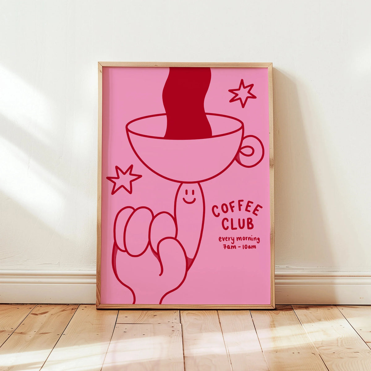 Arte de pared enmarcado en rosa que representa una mano sosteniendo una taza de café en silueta y una estrella estilizada.