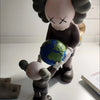 A stylized figurine of a bear character holding a globe, depicting a street art desk statue.