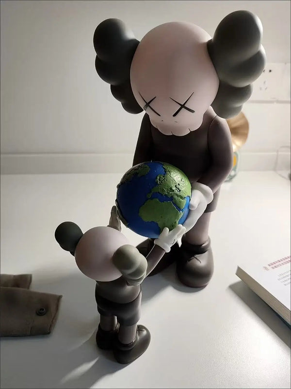 A stylized figurine of a bear character holding a globe, depicting a street art desk statue.