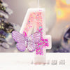 A white birthday candle shaped like the number 4 decorated with pink glitter and a purple butterfly.