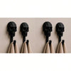 A row of black 3D skull wall hooks displaying gothic decor for hanging towels and coats.