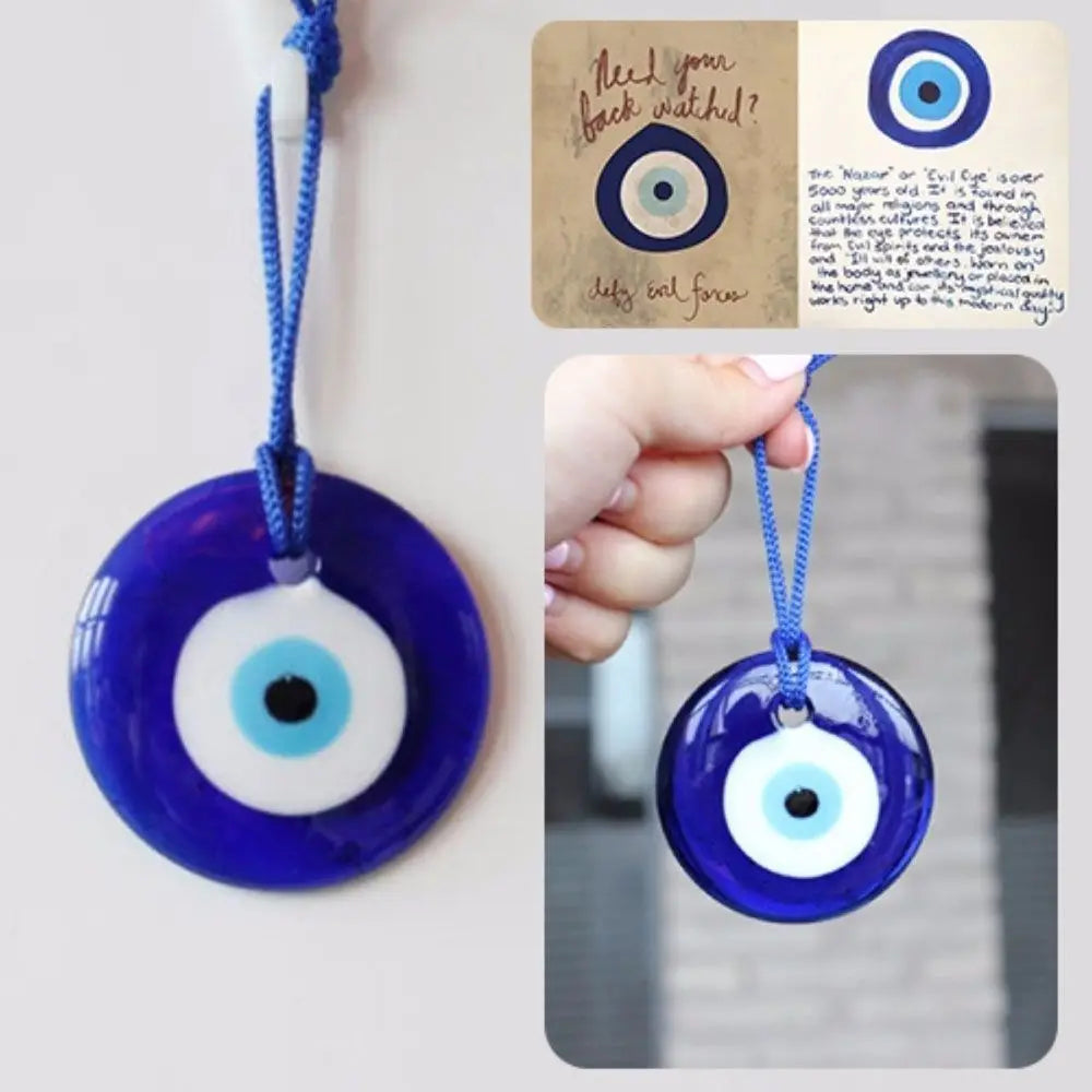 A blue glass evil eye amulet pendant with a white iris and a black pupil, suspended by a blue cord.
