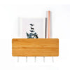 A light wood bamboo wall-mounted key rack with six hooks and a vertical wooden rod.