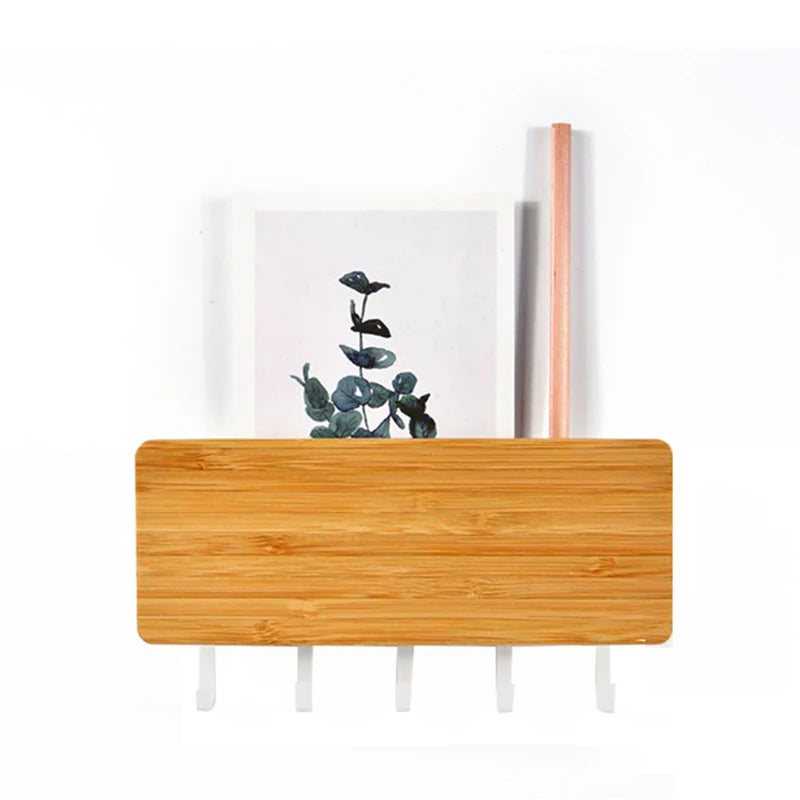 A light wood bamboo wall-mounted key rack with six hooks and a vertical wooden rod.