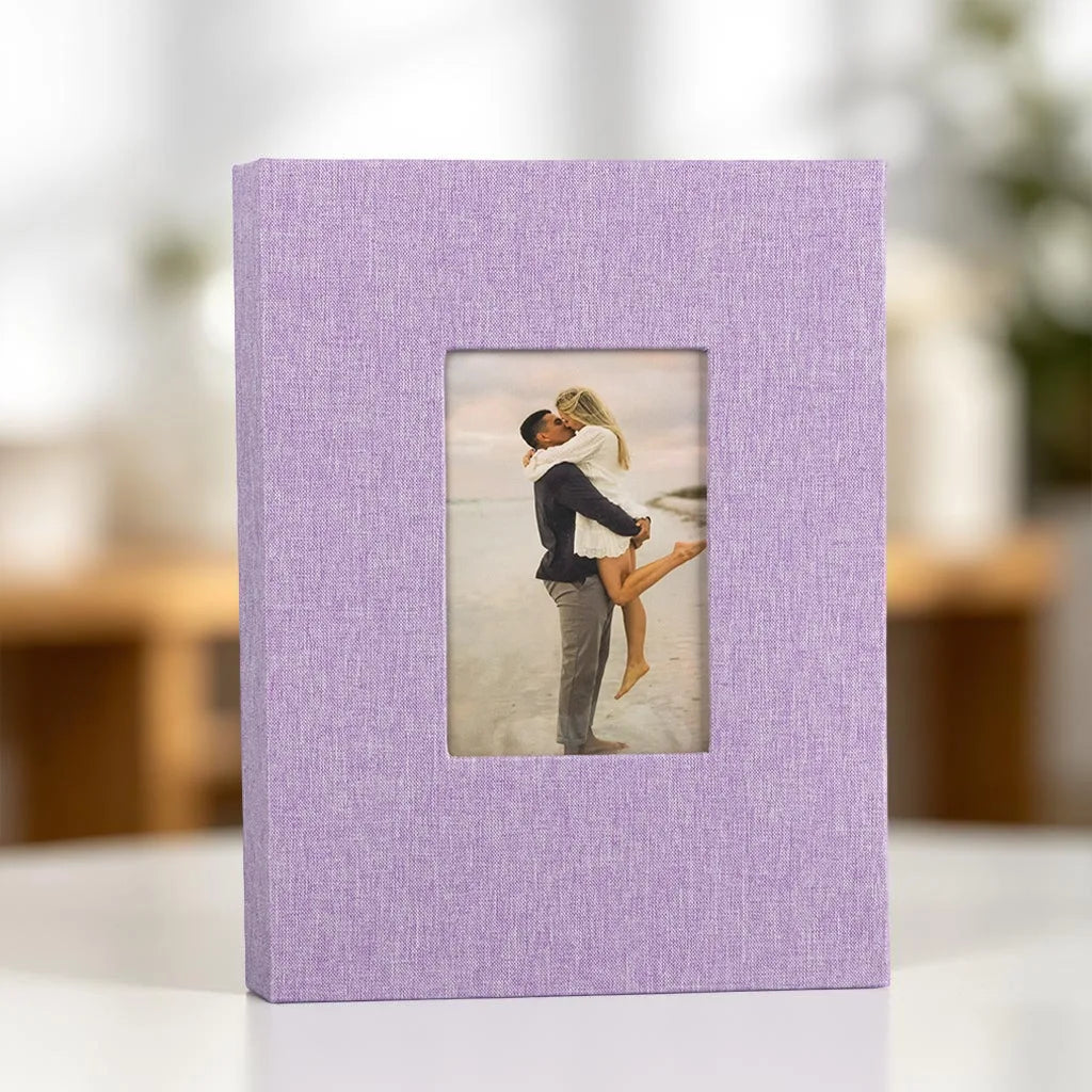 A purple linen photo album with a square display window showing a couple embracing.