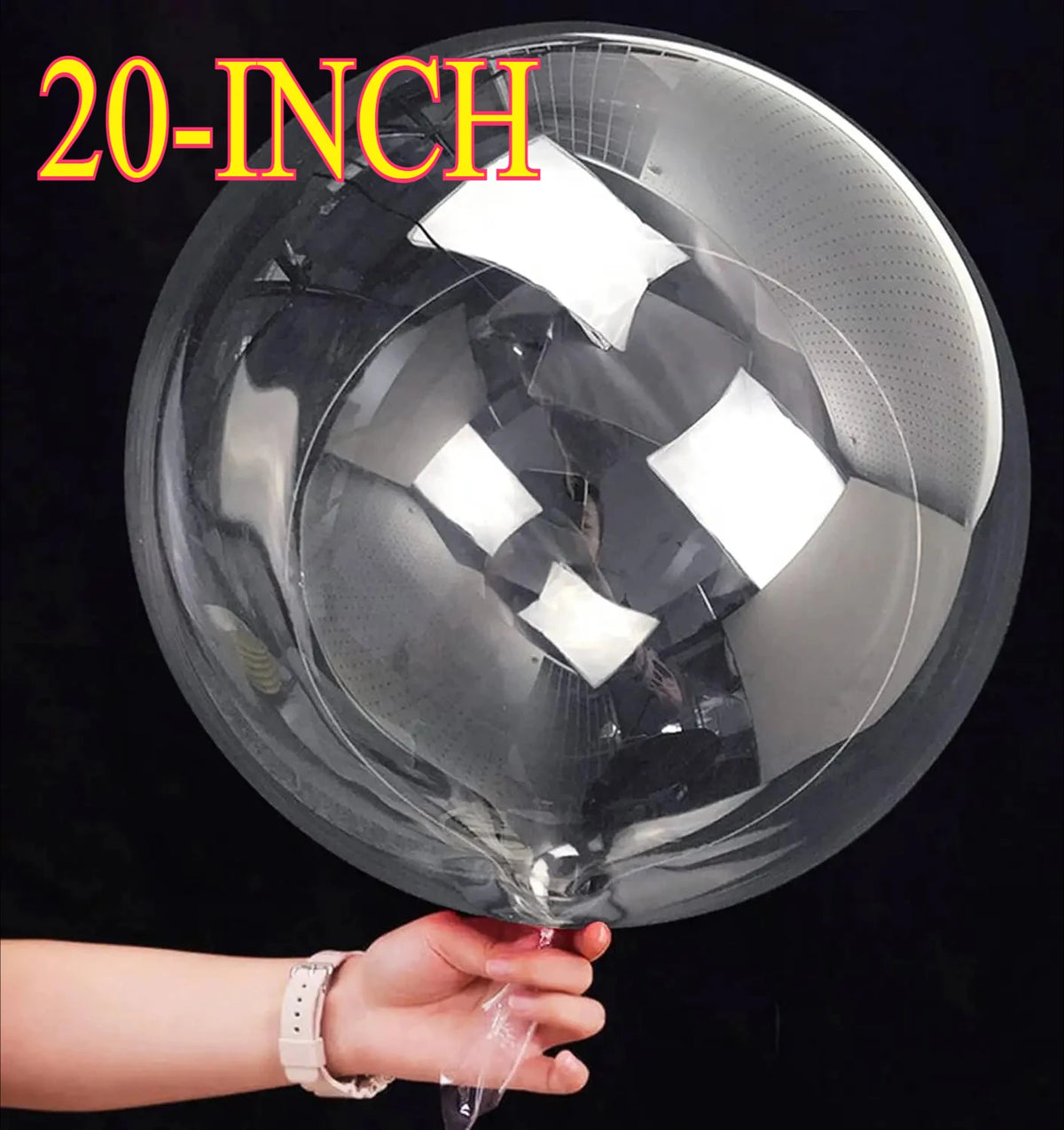 A hand holds a large 20-inch clear bubble balloon, showing its reflective surface.