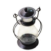 A decorative metal candlestick lantern with a glass globe and a dark lid.