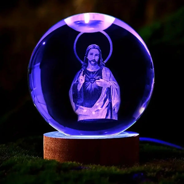 A glowing blue crystal ball night light featuring a silhouette of Jesus with a halo.