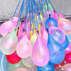 A collection of colorful water balloons, including pink, yellow, and blue, are suspended by strings.