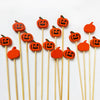 Orange pumpkin-shaped cocktail picks with a pearl finish on bamboo sticks