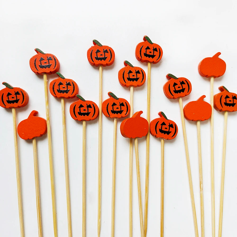 Orange pumpkin-shaped cocktail picks with a pearl finish on bamboo sticks