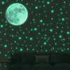 A dark green wall decorated with glowing, neon green stars and a large, bright cyan moon.