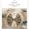 A round gold-toned wall clock featuring metal ginkgo leaf accents and a decorative design.