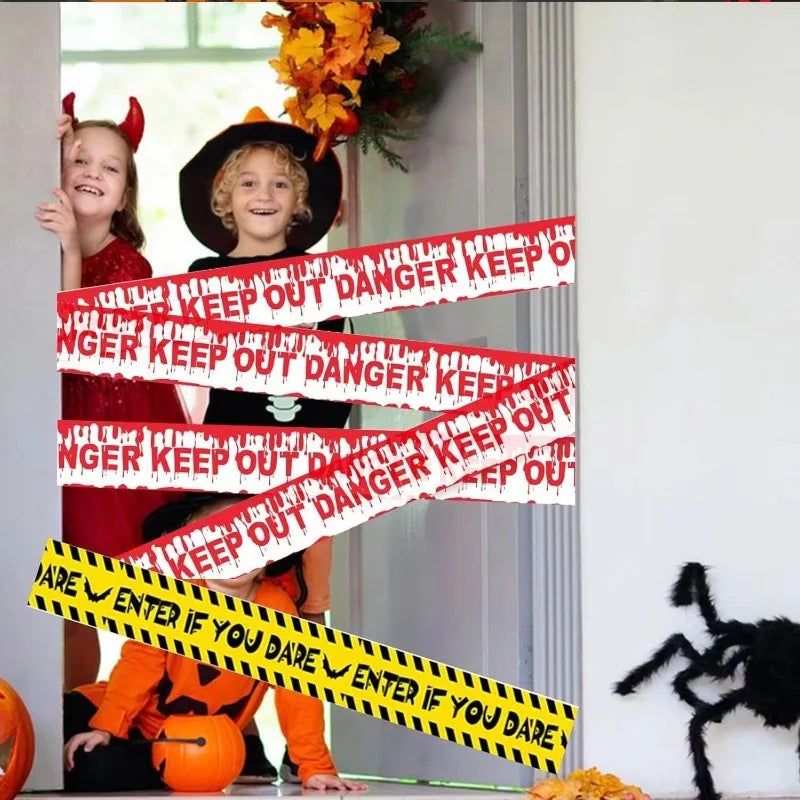 A Halloween caution tape sign with warning text across the frame, featuring a smiling child and a dark hat.
