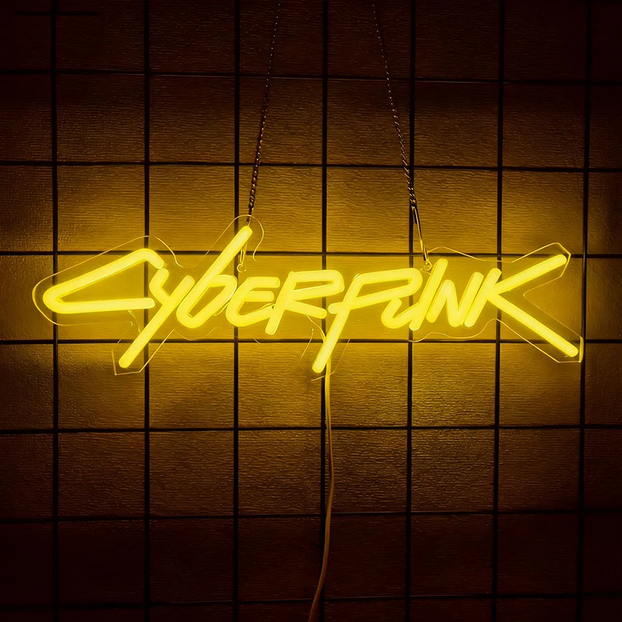A glowing yellow neon sign spelling out CYBERPUNK hanging against a dark, grid-patterned wall.