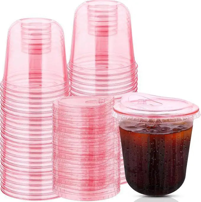 A stack of pink disposable plastic cocktail cups is shown, with one cup filled with a dark liquid.