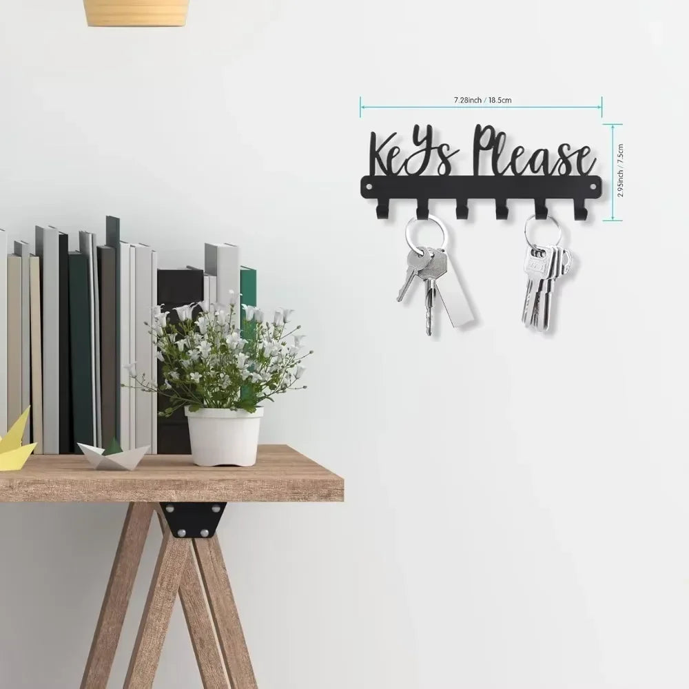 Black wall-mounted metal key holder with hooks displaying the text Keys Please