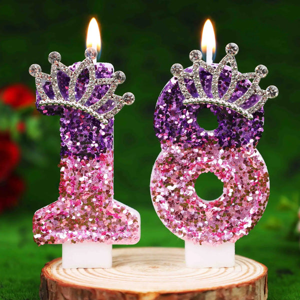 Glitter number 18 birthday candle with rhinestone crown cake topper on a wooden surface.