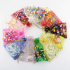 A circular arrangement of decorative organza drawstring bags featuring colorful moon and star patterns.