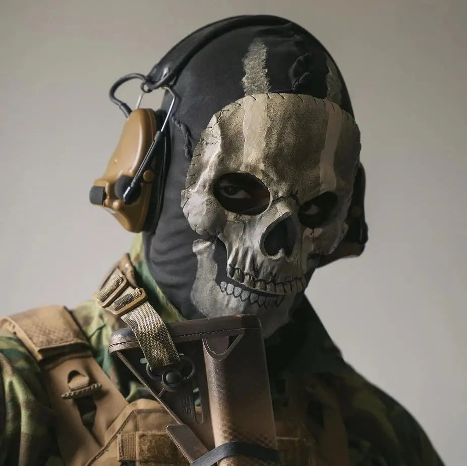 Persona usando una máscara facial completa de silicona táctica con diseño de calavera y protección para los oídos, visible en