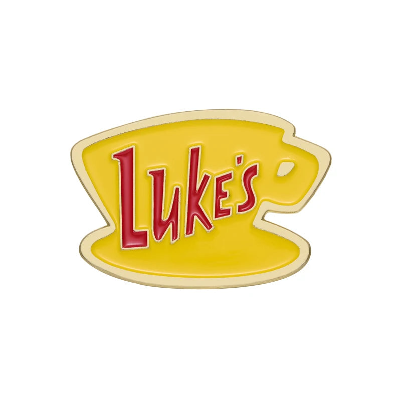 A yellow enamel pin featuring the text Luke's in red script on a light yellow background.