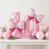 Pink foil number balloons shaped like the number 8 and 0 with bow accents