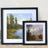 A black framed photo featuring a scenic landscape with trees and mountains.