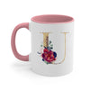 A pink ceramic coffee mug featuring a gold letter initial design with watercolor flowers.