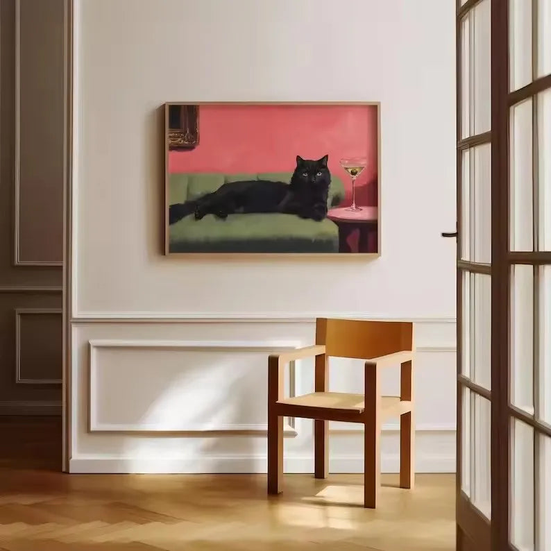 لوحة لقط أسود مستلقٍ على أريكة خضراء مع كوكتيل في كأس على طاولة حمراء
