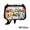 Schwarzer Folienball in Form eines Mundes mit bunten Buchstaben „WELCOME BACK“ und Schulmaterialien.