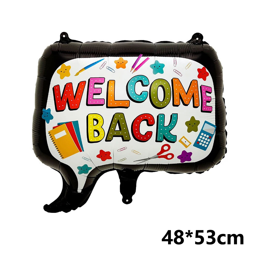 Schwarzer Folienball in Form eines Mundes mit bunten Buchstaben „WELCOME BACK“ und Schulmaterialien.