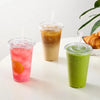 Three clear plastic cups filled with colorful beverages are displayed on a white surface.