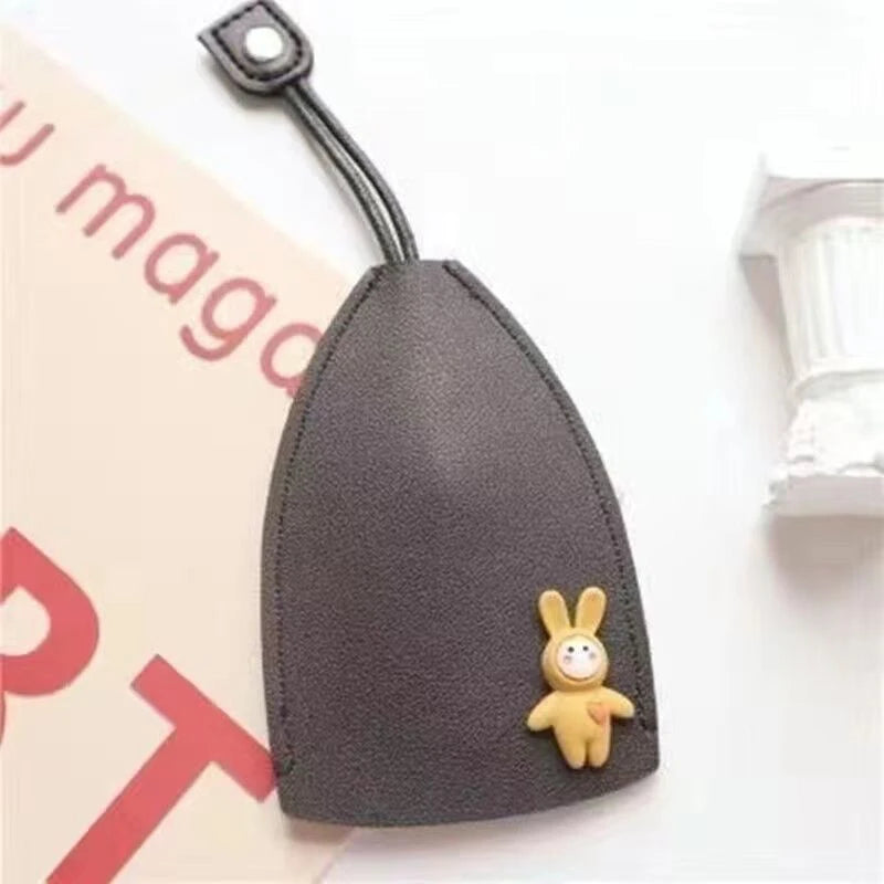 A dark gray cartoon PU leather key holder with a pull-out design featuring a small yellow bunny charm.