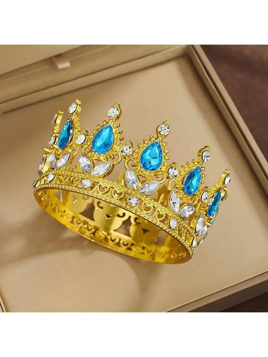 A gold crystal rhinestone crown featuring blue gemstones and animal motifs displayed in a box.