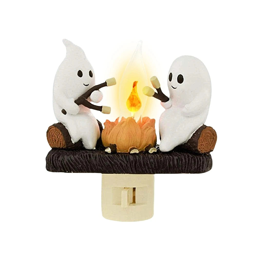 A white ghost figurine is sitting next to a flickering orange flame, creating a night light effect.
