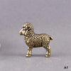 A vintage brass tiger figurine, a miniature animal statue, is shown against a gray background.