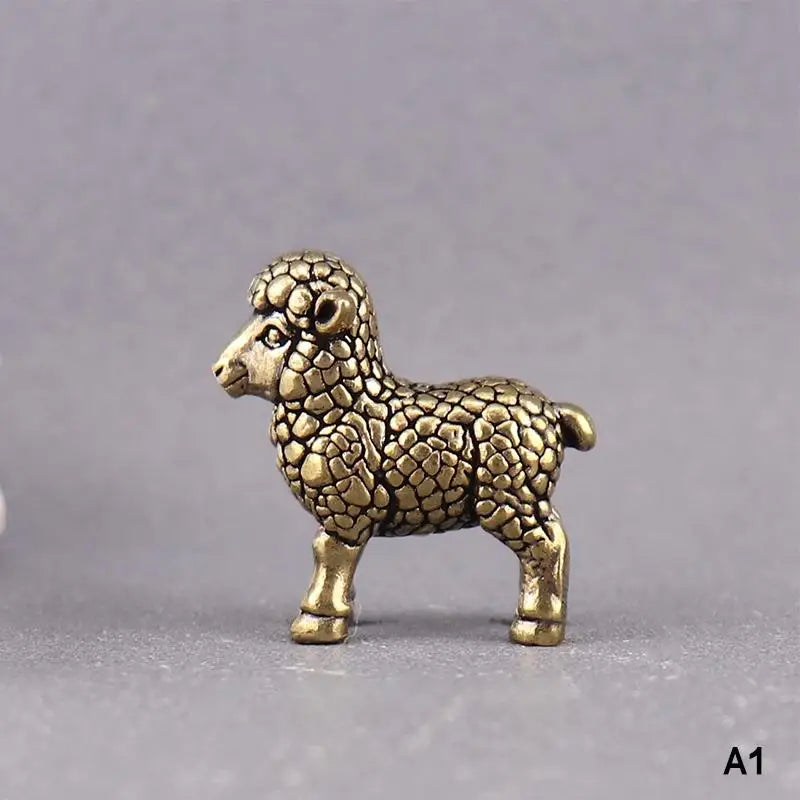 A vintage brass tiger figurine, a miniature animal statue, is shown against a gray background.