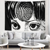 Black and white tapestry featuring a stylized human eye and facial features.