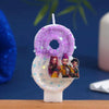 A set of purple and iridescent glitter birthday candles shaped like numbers 0 through 9