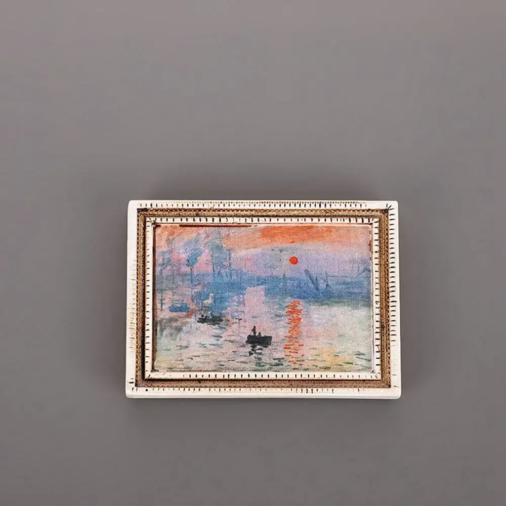 A framed painting featuring a landscape with vibrant orange and pink tones, depicting a river scene.