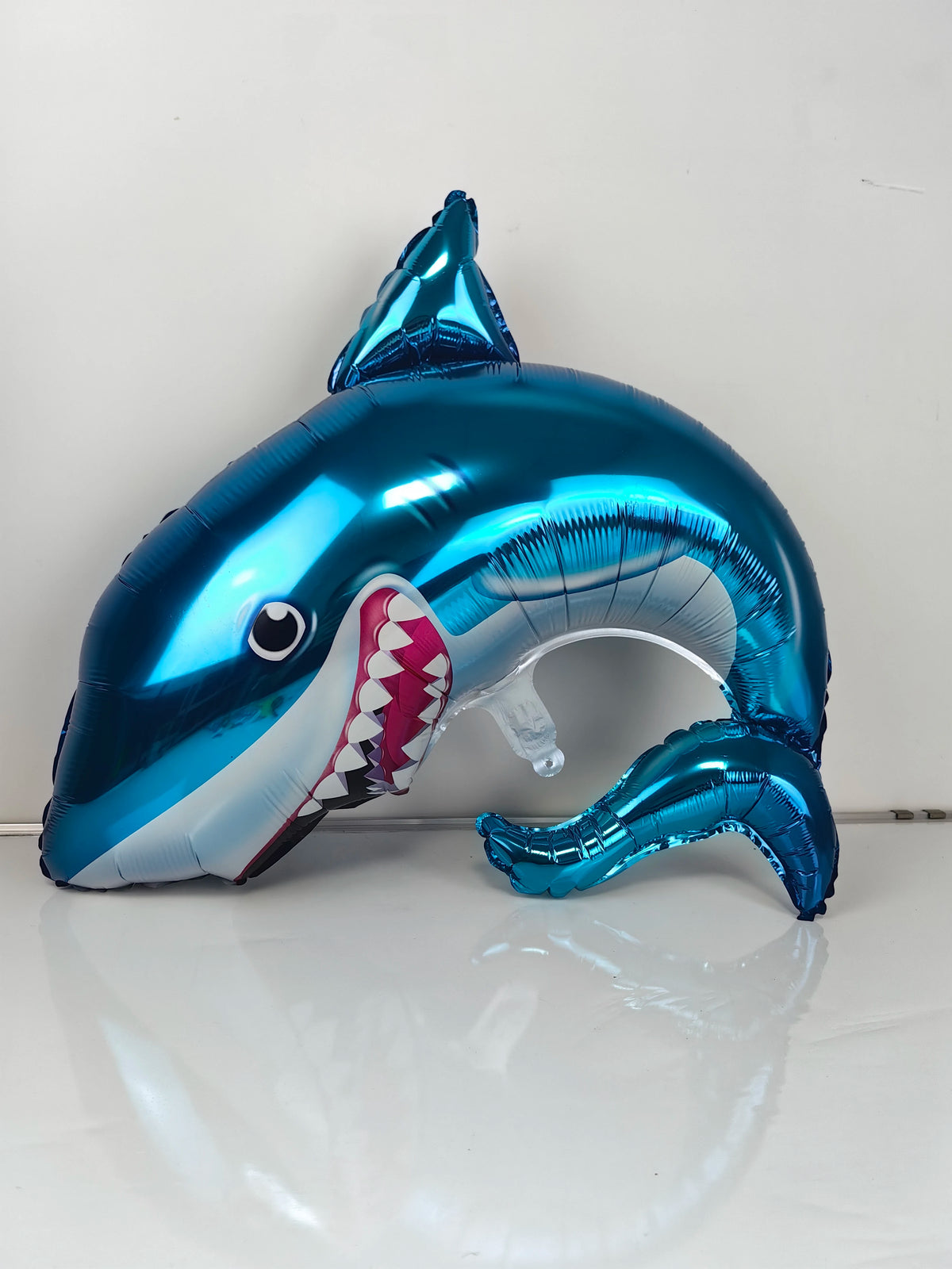 A blue shark foil balloon shaped like an ocean creature, used as a party decoration.