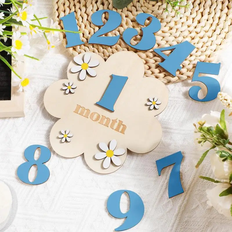 Wooden monthly milestone cards showing numbers 1 through 9 cut from light wood and blue acrylic.