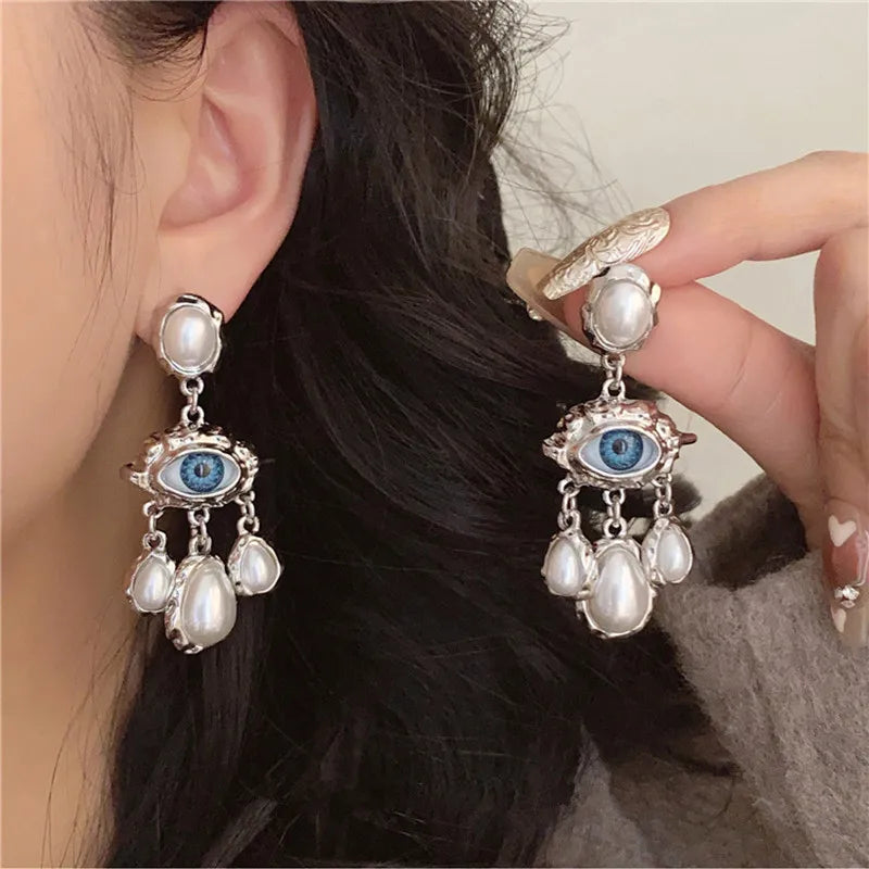 Silver pearl drop earrings featuring a blue eye motif and multiple white pearls