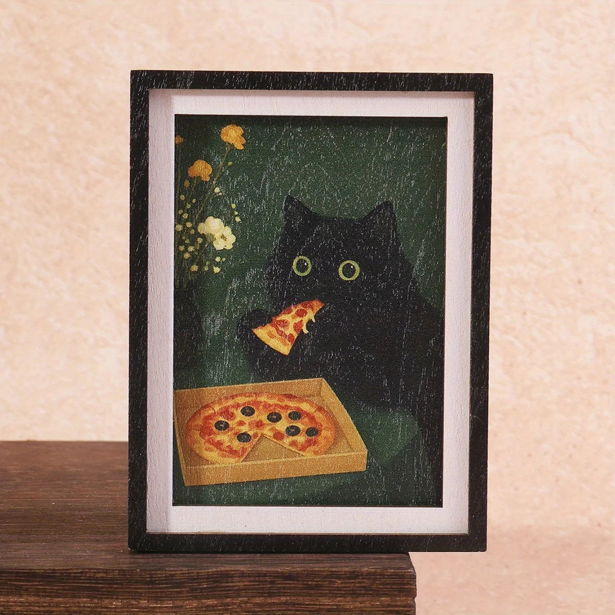A framed print featuring a black cat and a slice of pizza against a dark green background.