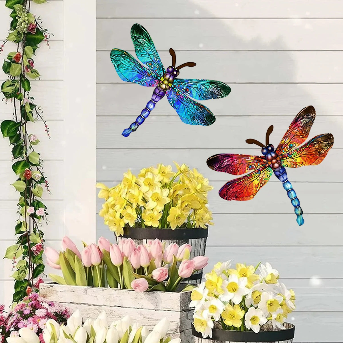 Vintage dragonfly wall art sculpture with iridescent blue and green wings displayed above fresh spring flowers.
