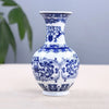 A blue and white ceramic flower vase with intricate floral patterns on a light surface.