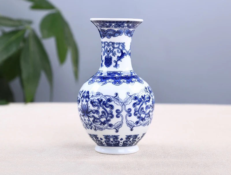 A blue and white ceramic flower vase with intricate floral patterns on a light surface.