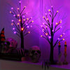 A glowing Halloween birch tree lamp featuring multiple LED lights and skull decorations.