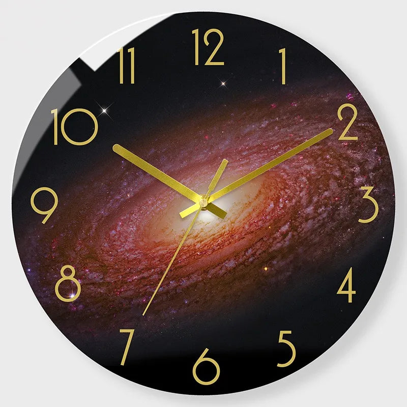 A round wall clock face showing a night sky or galaxy background with gold hour markers and hands.